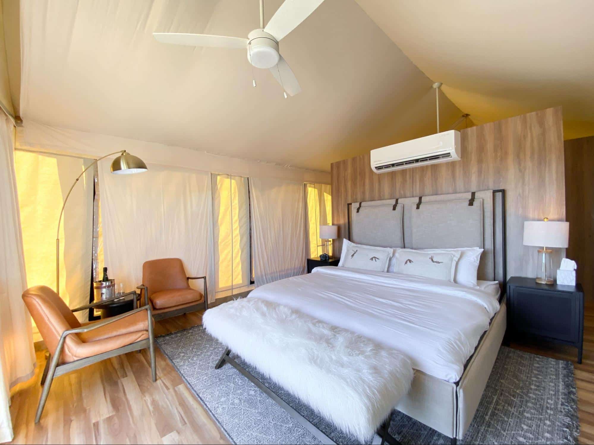 Luxury tent suite interior at Camp Hideaway Fredericksburg — king bed, canvas walls, climate control