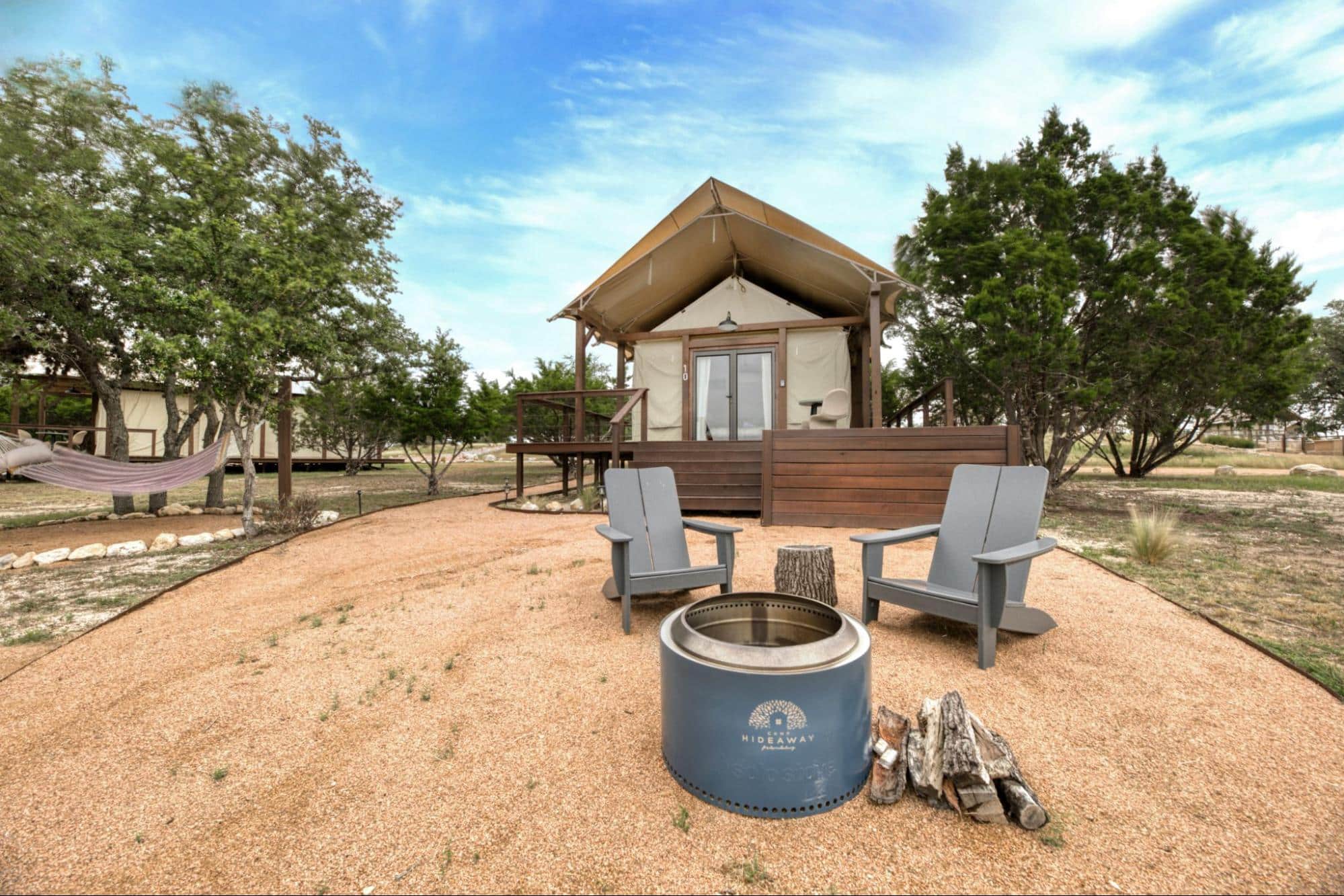 Private glamping tent exterior with fire pit at Camp Hideaway — off-the-grid cabin rental in the Texas Hill Country